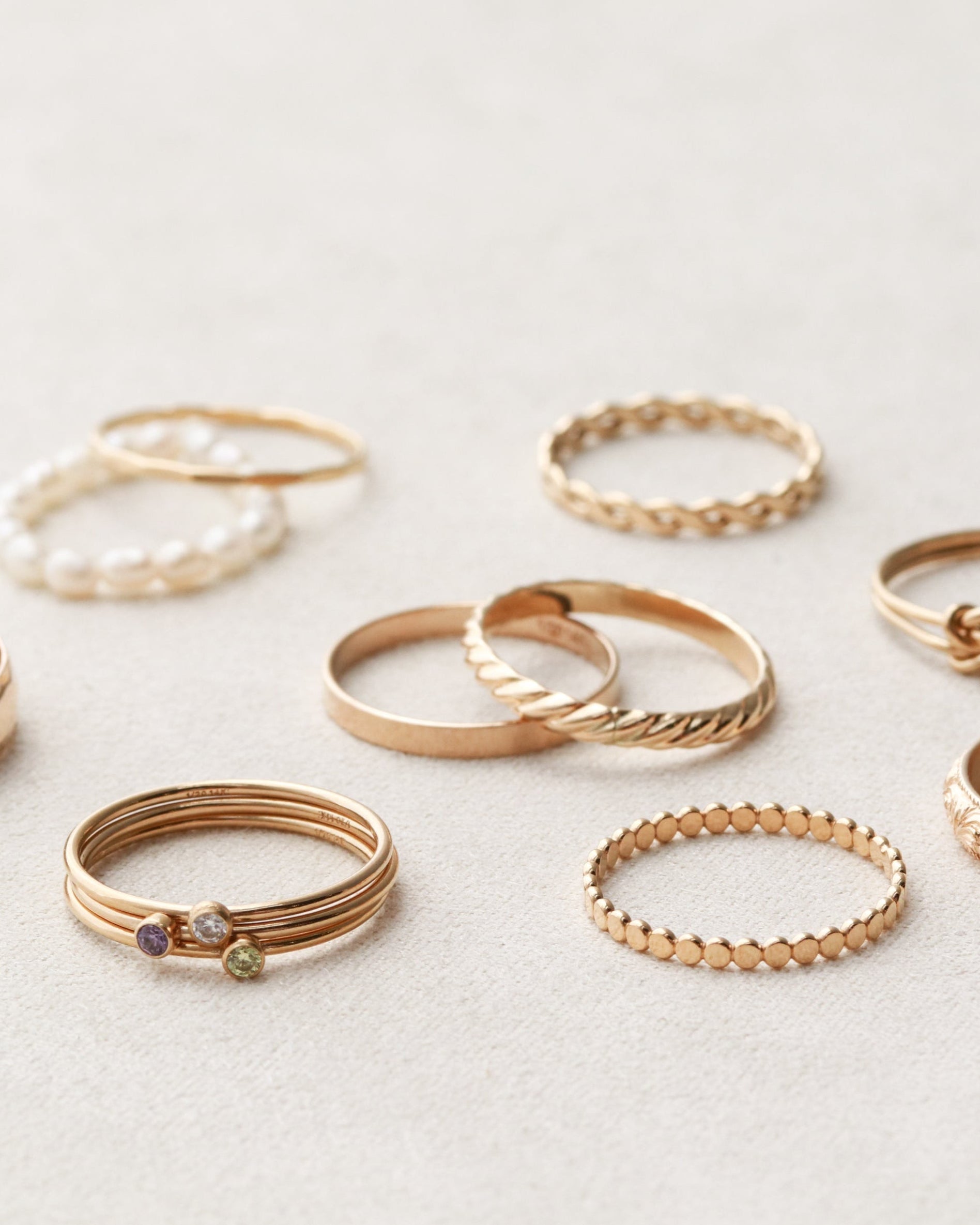 Collection of gold rings on a light gray background