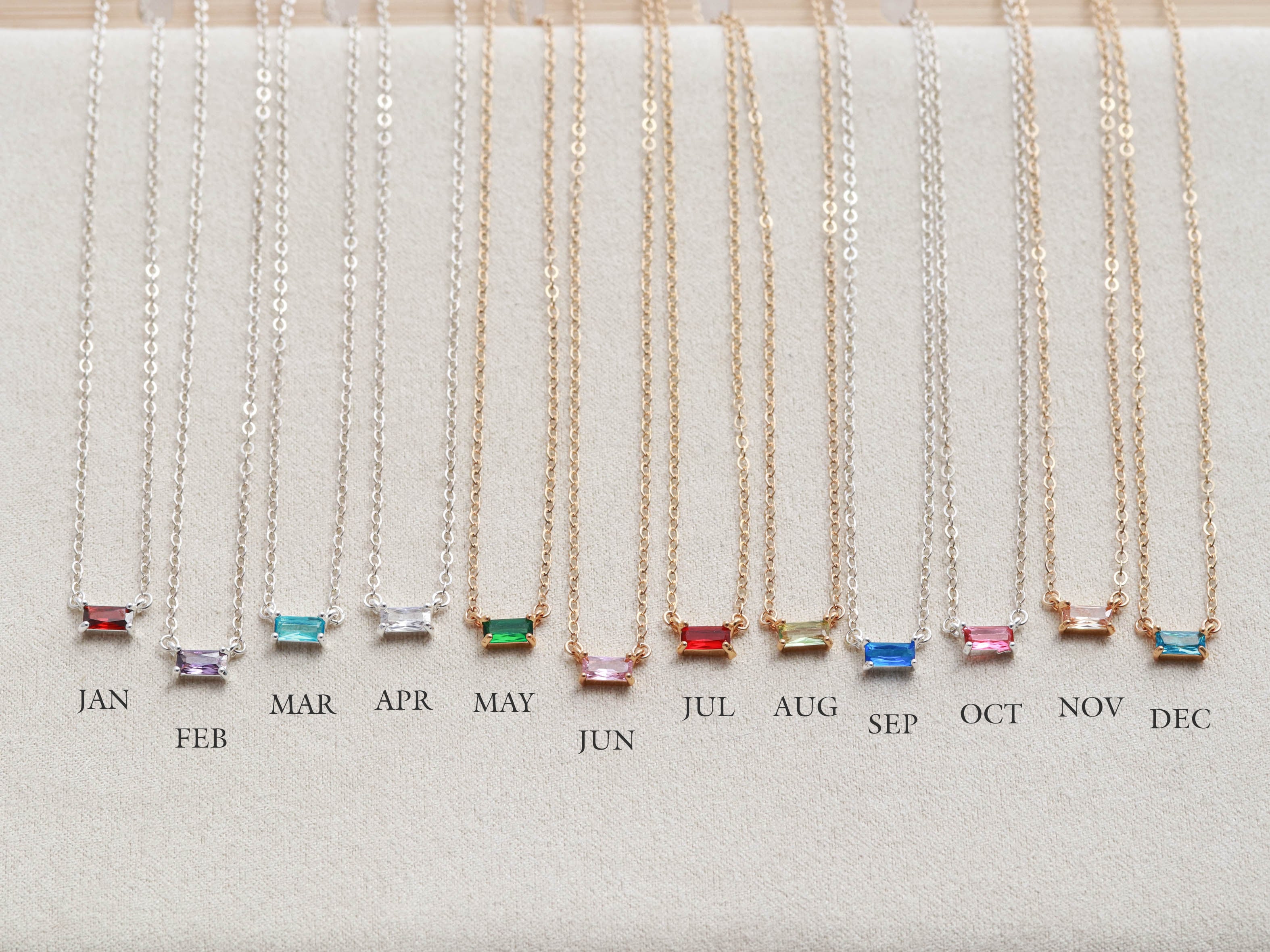 A custom necklace with birthstone baguette and solitaire stones.