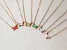 A group of customized gemstone baguette necklaces from Tom Design.