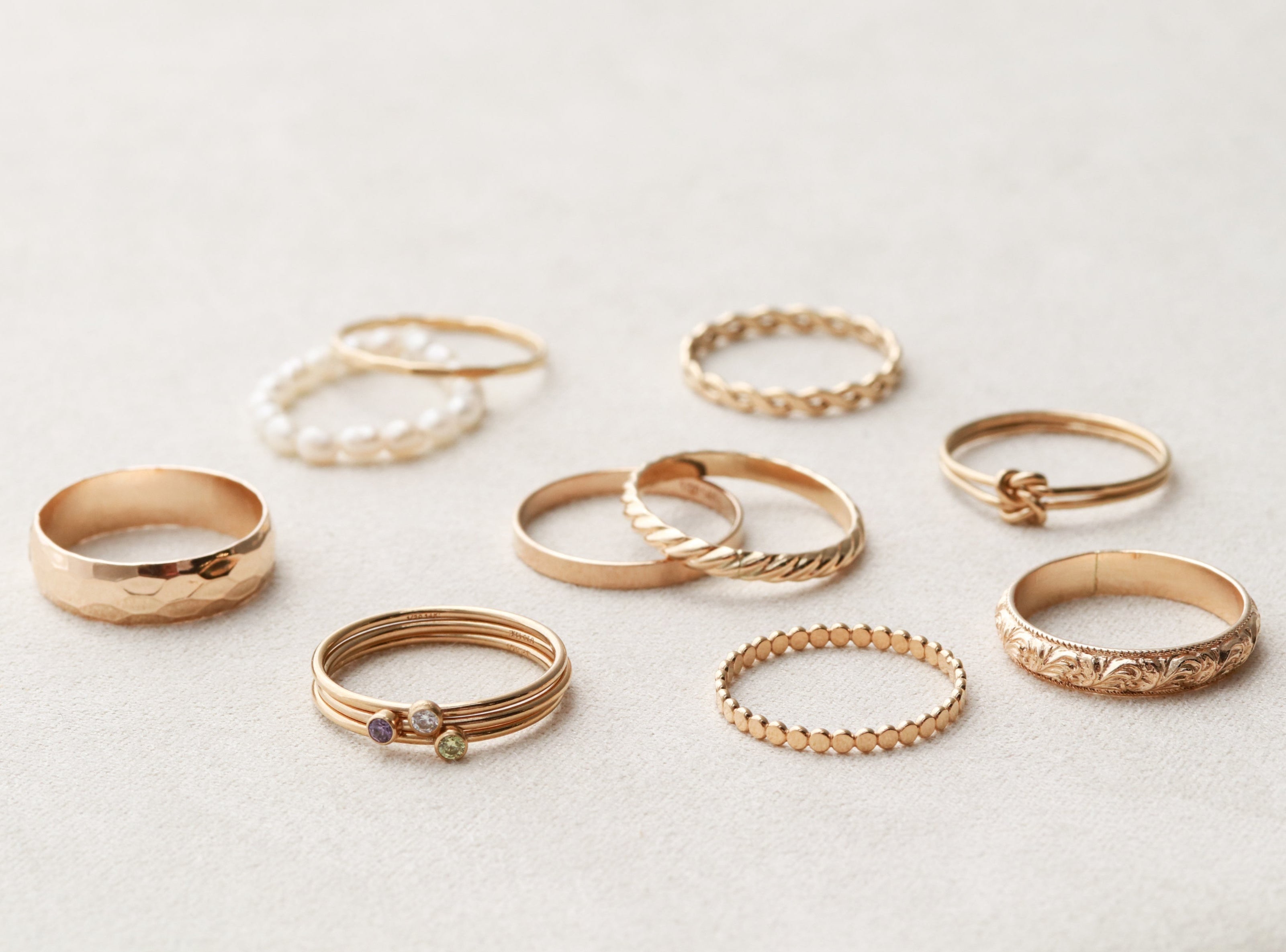 Collection of gold rings on a light gray background