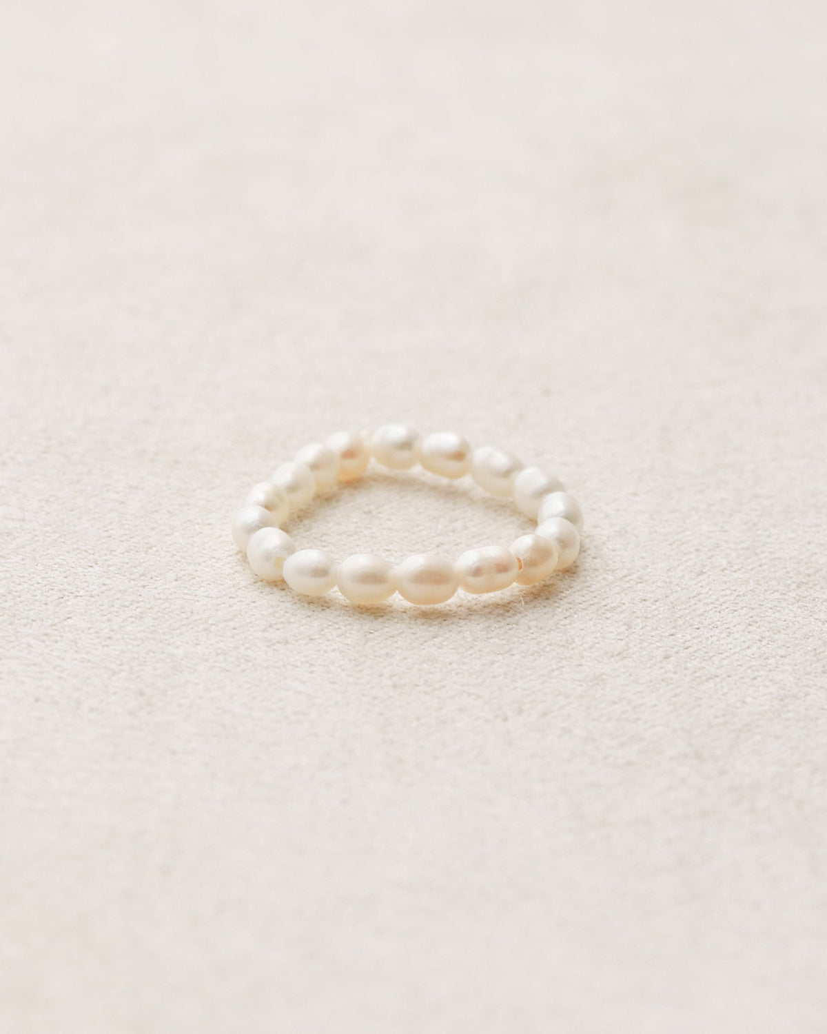 Pearl ring on a light beige background