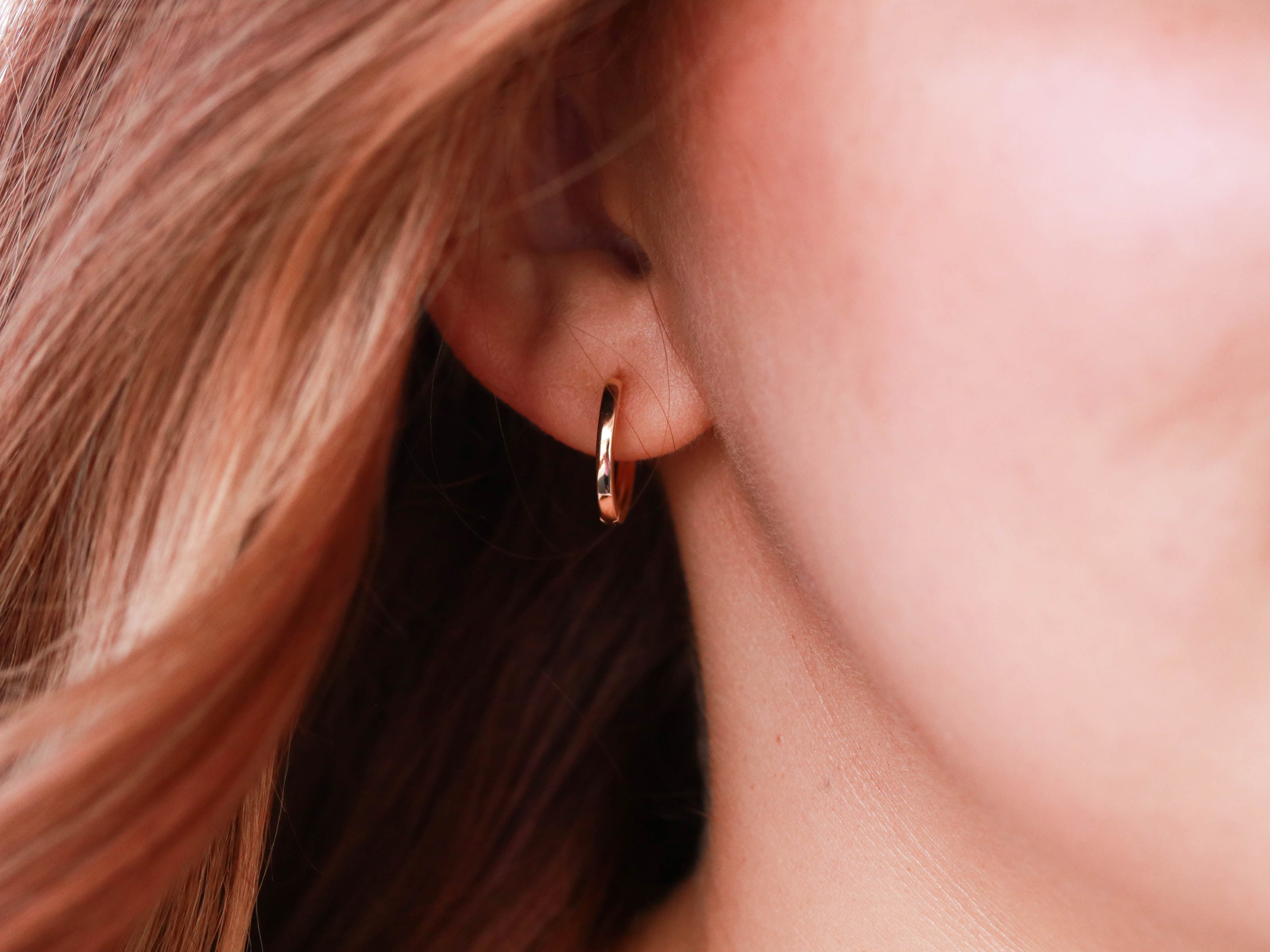 gold hoop earring on model